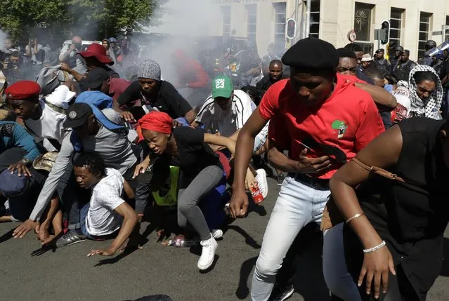 Students run for cover as police fired stun grenades and rubber bullets in an attempt to disperse them during a protest, in Johannesburg, South Africa, Wednesday, September 21, 2016. South African police on Wednesday set off stun grenades and threw tear gas at stone-throwing students from a leading university who were demonstrating for free education. (Photo by Themba Hadebe/AP Photo)