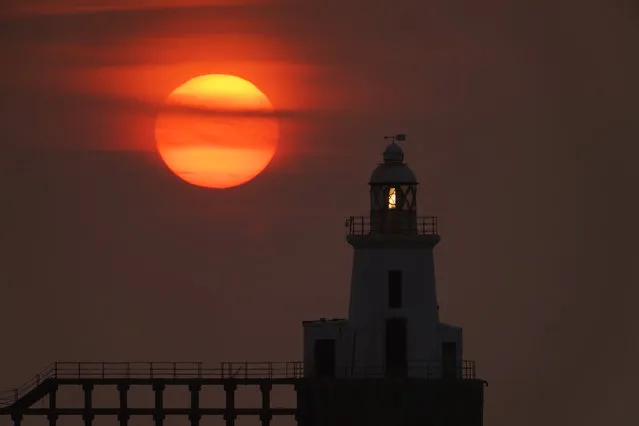 The sun rises behind Blyth East Pier Lighthouse in Northumberland, England on August 11, 2020. (Photo by Owen Humphreys/PA Images via Getty Images)