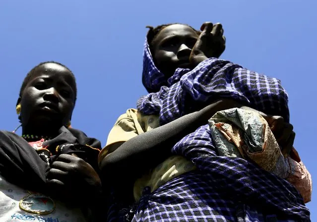 Displaced people gather to receive food provided by the United Nations' World Food Programme (WFP) during a visit by a European Union delegation, at an IDP camp in Azaza, east of Ad Damazin, capital of Blue Nile state, October 21, 2015. (Photo by Mohamed Nureldin Abdallah/Reuters)