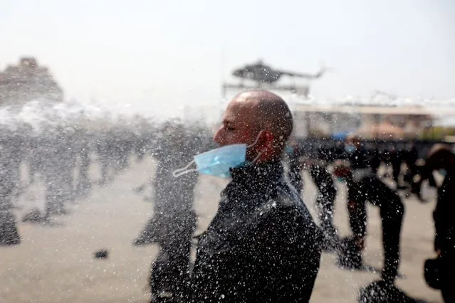 Palestinian police staff affiliated to Hamas interior ministry in Gaza are sprayed with disinfectant during a training session to new police forces to be deployed in the emergency plan to support fighting the spread of the corona virus disease (COVID-19), in Gaza City September 17, 2020. (Photo by Majdi Fathi/NurPhoto via Getty Images)