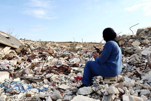 Lebanese woman Manar Feres, who returned to Kfar Kila following Israeli troop withdrawal, sits on the rubble of her damaged home, in Kfar Kila near the border with Israel, Lebanon on February 18, 2025. (Photo by Emilie Madi/Reuters)