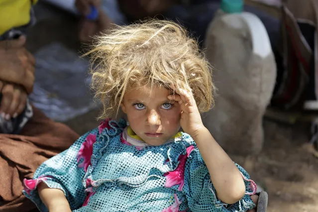 A girl from the minority Yazidi sect, fleeing the violence in the Iraqi town of Sinjar, rests at the Iraqi-Syrian border crossing in Fishkhabour, Dohuk province, August 13, 2014. (Photo by Youssef Boudlal/Reuters)