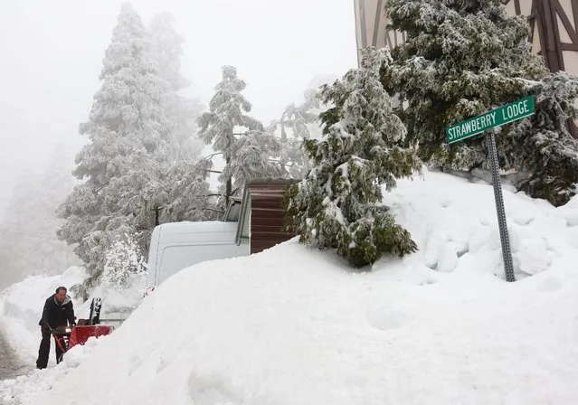 Richard Pelayo clears snow from his driveway after a series of winter storms dropped more than 100 inches of snow in the San Bernardino Mountains in Southern California on March 6, 2023 near Twin Peaks, California. Some residents have been stranded in the area for more than ten days due to the snowfall while running low on food, supplies and medicine. California Governor Gavin Newsom declared a state of emergency due to winter storms for 13 counties including San Bernardino County and the California National Guard is assisting relief efforts in the mountains. (Photo by Mario Tama/Getty Images)