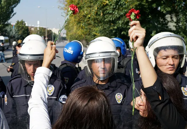 Riot police stop women holding carnations as they march to commemorate last year's deadly suicide bombing near the main train station in Ankara, Turkey, October 10, 2016. (Photo by Umit Bektas/Reuters)