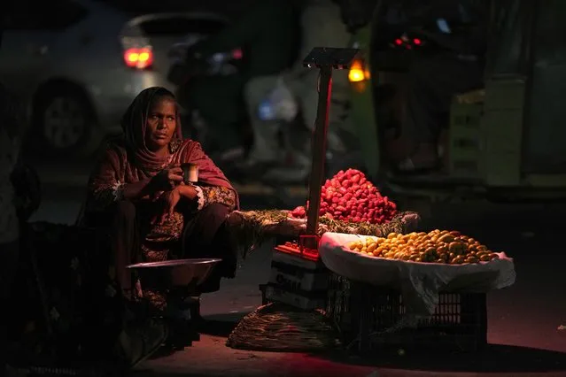 A woman, who sells fruit to earn a living for her family, waits for customers along roadside, in Lahore, Pakistan, Tuesday, March 7, 2023. Pakistan is observing the International Women's Day with other nations. (Photo by K.M. Chaudary/AP Photo)