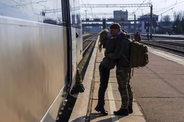 A Ukrainian serviceman kisses his partner at the train station in Kramatorsk, Ukraine, Thursday, March 23, 2023. (Photo by Evgeniy Maloletka/AP Photo)