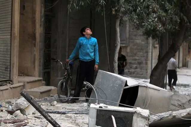 A youth inspects a damaged site after an airstrike in the besieged rebel-held al-Qaterji neighbourhood of Aleppo, Syria October 14, 2016. (Photo by Abdalrhman Ismail/Reuters)