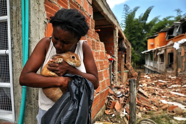 A woman embraces a rabbit rescued from the debris of destroyed houses after an attack that authorities blame on a dissident faction of the Revolutionary Armed Forces of Colombia (FARC) in Robles, Colombia, Thursday, October 9, 2025. (Photo by Santiago Saldarriaga/AP Photo)