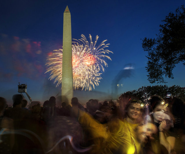 Revellers pose for cell phone snapshots during the annual Independence Day fireworks display at the Washington Monument on July 4, 2014 in Washington, DC. (Photo by Bill O'Leary/The Washington Post)