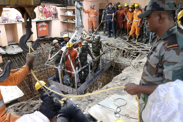 Rescuers work at the site of a structure built over an old temple well that collapsed Thursday as a large crowd of devotees gathered for the Ram Navami Hindu festival, in Indore, India, Friday, March 31, 2023. Thirty-five bodies have been found inside a well at a Hindu temple in central India after dozens of people fell into the muddy water when the well's cover collapsed. (Photo by AP Photo/Stringer)