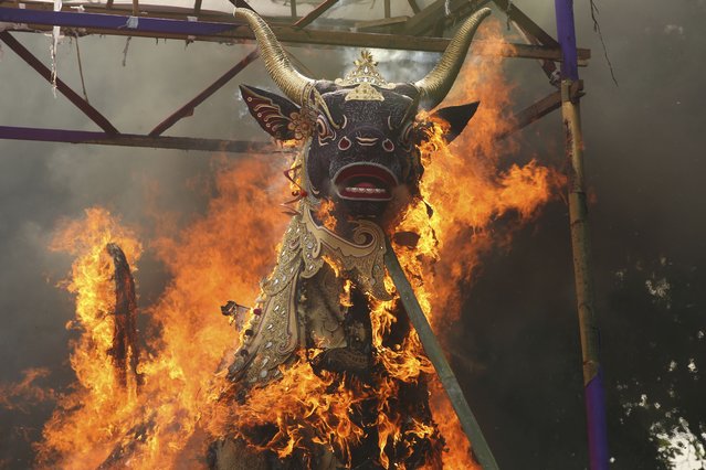 A giant effigy in form of a bull, with the coffin containing the body of Tjokorda Rai Dharmawati, a member of Ubud royal family, is in flames during a Balinese royal cremation ceremony called “pelebon” in Ubud, Bali, Indonesia Monday, June 10, 2024. Thousands of people attended the cremation ceremony for Tjokorda Rai Dharmawati who died in May at the age of 60. (Photo by Firdia Lisnawati/AP Photo)