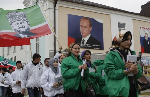 Members of a youth club supporting former Chechen leader Akhmad Kadyrov (printed on flag) march along a street during a rally in the centre of the Chechen capital Grozny April 25, 2013. (Photo by Maxim Shemetov/Reuters)