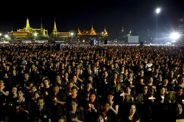 Thai mourners hold candles and sing a special version of Thailand's royal anthem in honor of King Bhumibol Adulyadej in front of Grand Palace in Bangkok, Thailand, Saturday, October 22, 2016. King Bhumibol died on Oct. 13 at the age of 88. (Photo by Wason Wanichakorn/AP Photo)
