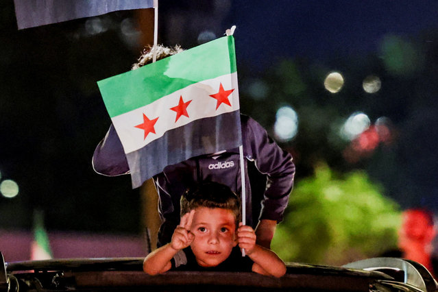 A child holds a Syrian flag as people gather at Umayyad Square in Damascus to watch a broadcast of Syrian President Ahmed Al-Sharaa delivering a speech at the United Nations, in Syria, on September 24, 2025. (Photo by Khalil Ashawi/Reuters)