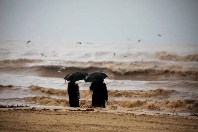 Ultra-Orthodox Jewish men hold umbrellas and look at the Mediterranean Sea as heavy rainfalls hit Israel, in Ashdod, Israel on January 9, 2020. (Photo by Amir Cohen/Reuters)