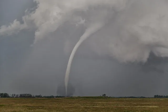 A tornado begins to dissipate and starts to resemble a rope, on June 18, 2014, in Woonsocket, South Dakota. (Photo by Roger Hill/Barcroft Media)