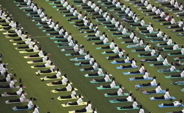 Hundreds of participants practice yoga at a charity event to mark the upcoming World AIDS Day, at an university in Guilin, Guangxi Zhuang Autonomous Region, China, November 29, 2015. (Photo by Reuters/Stringer)