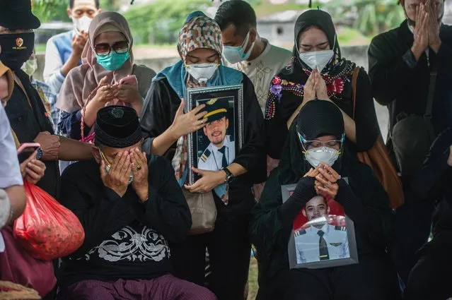 Relatives of Fadly Satrianto, a co-pilot with Nam Air and a passenger onboard Sriwijaya Air flight SJ182 which crashed into the Java sea minutes after takeoff from Jakarta on January 9, pray during his funeral in Surabaya on January 15, 2021. (Photo by Juni Kriswanto/AFP Photo)