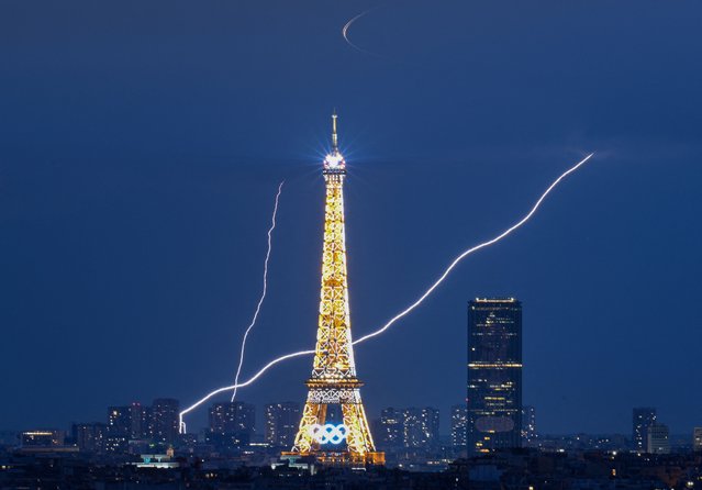 A lightning strike is seen close to the Eiffel Tower during the Paris 2024 Olympic Games in Paris on August 1, 2024. (Photo by Luis Robayo/AFP Photo)