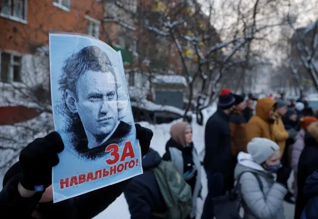 A man holds a placard reading “For Navalny!” as people, including supporters of Alexei Navalny, gather outside a police station where the Russian opposition leader is being held following his detention, in Khimki outside Moscow, Russia on January 18, 2021. (Photo by Maxim Shemetov/Reuters)