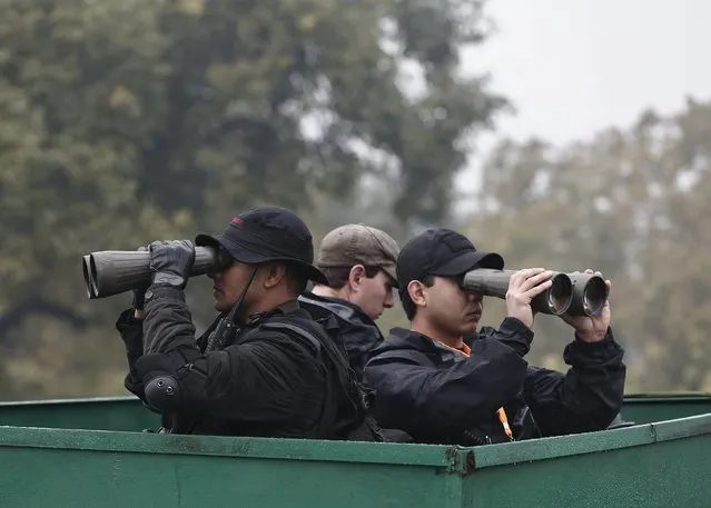 Security personnel look through binoculars as they keep vigil over the venue for the Republic Day parade in New Delhi January 26, 2015. (Photo by Adnan Abidi/Reuters)