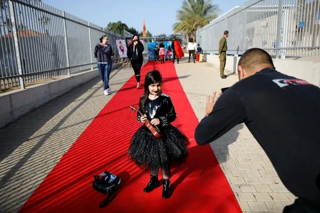 A father photographs his daughter who is wearing a dress-up costume to mark the upcoming Jewish holiday of Purim, which is a celebration of the Jews' salvation from genocide in ancient Persia, at a school in Ashkelon, southern Israel on February 24, 2021. (Photo by Amir Cohen/Reuters)
