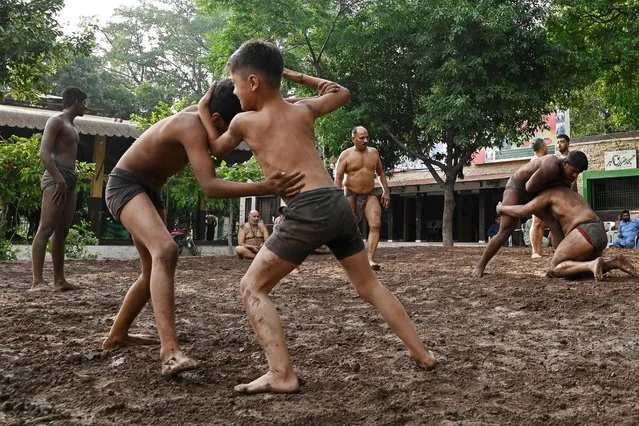 In this picture taken on June 16, 2023, 'Pehelwans' or traditional wrestlers take part in training session at the Muslim Health Club Akhara in Lahore. (Photo by Amna Yaseen/AFP Photo)