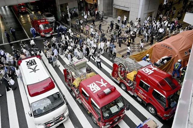 An ambulance and fire trucks park near the scene of a spray attack in Osaka, western Japan Wednesday, June 14, 2023. Police in the western Japanese city of Osaka said Wednesday they are searching for a suspect who sprayed an unknown liquid on several women inside a department store, causing pain to their faces and eyes. (Photo by Kyodo News via AP Photo)