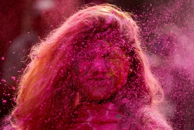 A woman daubed in colours reacts as colour powder is thrown towards her during Holi celebrations in Chennai, India, March 29, 2021. (Photo by P. Ravikumar/Reuters)