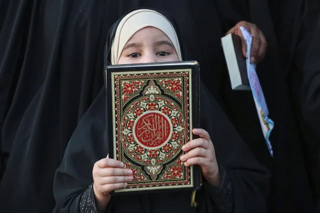 A supporter of the Shiite cleric Muqtada al-Sadr holds the Quran, the Muslim holy book, in response to the burning of a copy of the Quran in Sweden, during a rally in Basra, Iraq, Sunday, July 2, 2023. (Photo by Nabil al-Jurani/AP Photo)