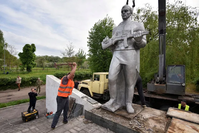 A worker dismantles a sculpture of a Soviet soldier from the Eternal Flame memorial complex created by the Soviet authorities, amid Russia's invasion of Ukraine, in Chervonohrad, Lviv region, Ukraine on May 13, 2022. (Photo by Pavlo Palamarchuk/Reuters)