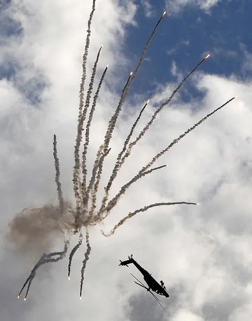A Dutch AH-64 Apache helicopter fires flares during a performance at the International Air Show in Radom, Poland, on August 24, 2013. (Photo by Czarek Sokolowski/Associated Press)