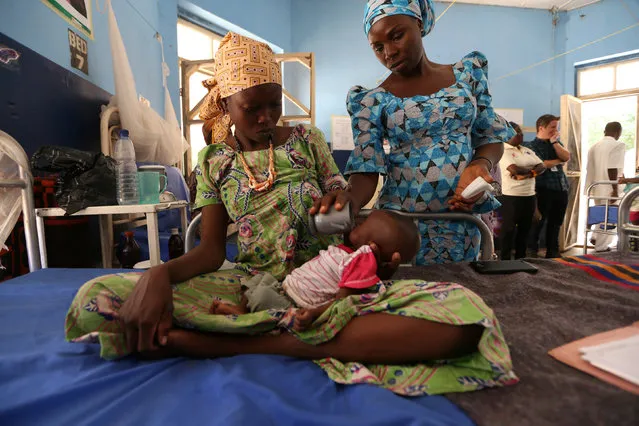 A nutritionist feeds a malnourished baby at the Molai General Hospital Maiduguri, Nigeria. November 30, 2016. The United Nations says 400,000 children are now at risk from a famine in the northeastern states of Borno, Adamawa and Yobe – 75,000 of whom could die from hunger within the next few months. (Photo by Afolabai Sotunde/Reuters)