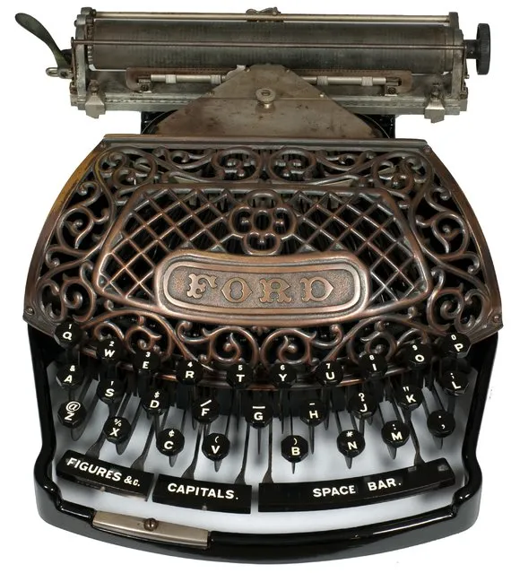Ford. Ford Typewriter Company, New York, 1895. The Ford typewriter is a striking machine with its beautiful ornate grill and gracefully integrated keyboard. It was a machine to grace the eyes but would not have endeared itself to the typist, as the keys are rather springy and wobbly when typing and the platen surprisingly does not have a line-by-line clicking action. Also the shift keys for capitals and figures require a solid push to operate, not a good design for fast typing. However, what the Ford did have was visible writing, allowing one to see the typed words on the platen as soon as they were typed. It was not the first to do this but most contemporary typewriters were still blind writers, requiring one to lift the carriage to see the last few typed lines. The Ford typewriter broke new ground in being the first typewriter to use the new metal “aluminum” in its construction. The Ford was sold in two versions, one with an all aluminum frame and carriage and the other with a cast iron, black enameled, frame and aluminum carriage, as shown above. Both sport a beautiful Japanned grill. (Photo and caption by Martin Howard/Martin Howard Collection)