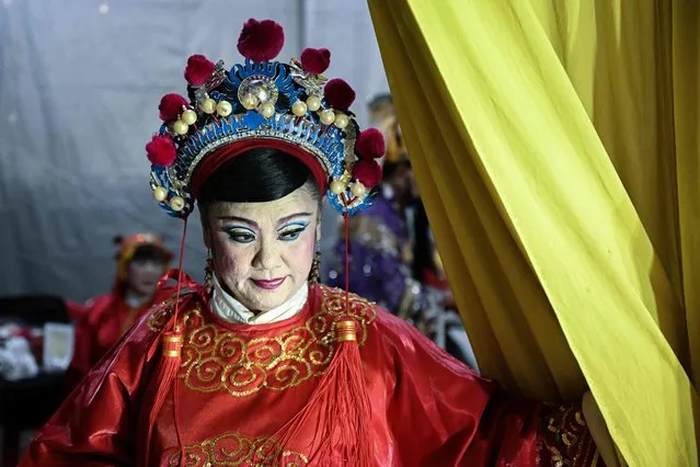 This picture taken on August 24, 2023 shows an ethnic Malaysian-Chinese artist preparing to perform a Chinese opera in front of empty seats believed to be seated by dead ancestors during the Hungry Ghost Festival in Kajang, Malaysia's Selangor state. The festival, celebrated in the seventh lunar month of the lunar new year calendar among communities in southern China, Malaysia, Singapore, Hong Kong and Taiwan, marks the belief that the 'Gates of Hell' are opened to let out the hungry ghosts who then wander in the land of the living while foraging for food. (Photo by Mohd Rasfan/AFP Photo)