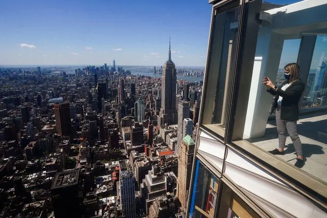 Alexis Tymorek takes pictures from the observation deck of the still under construction One Vanderbilt tower in the Manhattan borough of New York City, New York, U.S., May 11, 2021. (Photo by Carlo Allegri/Reuters)