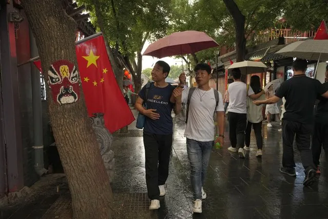 Visitors pass through the popular Nanluoguxiang alley way in Beijing on Saturday, July 3, 2021. (Photo by Ng Han Guan/AP Photo)
