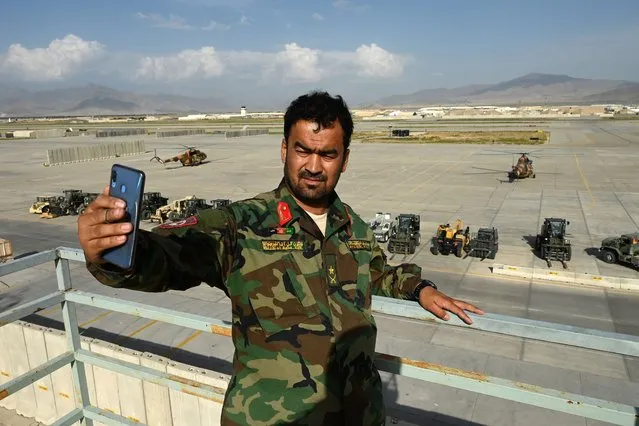 An Afghan National Army (ANA) soldier takes a selfie with his mobile phone inside the Bagram US air base after all US and NATO troops left, some 70 Kms north of Kabul on July 5, 2021. (Photo by Wakil Kohsar/AFP Photo)