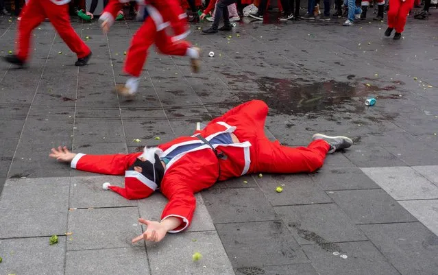 People roll around in the street as they take part in the SantaCon 2018 on December 8, 2018 in London, England. (Photo by Peter Dench/Getty Images)