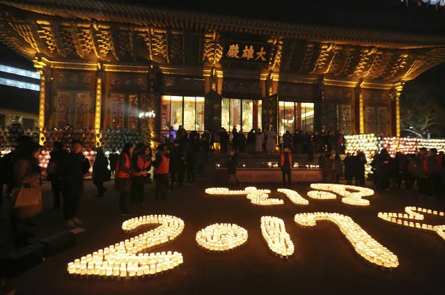 Buddhists light candles during New Year celebrations at Jogye Buddhist temple in Seoul, South Korea, early Sunday, January 1, 2017. (Photo by Ahn Young-joon/AP Photo)