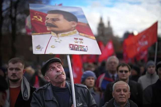 A communist party supporter holds a portrait of Soviet leader Josef Stalin during a demonstration near Red Square in Moscow, Russia, on Tuesday, November 7, 2023, as they gather to mark the 106th anniversary of the 1917 Bolshevik revolution. (Photo by Alexander Zemlianichenko/AP Photo)