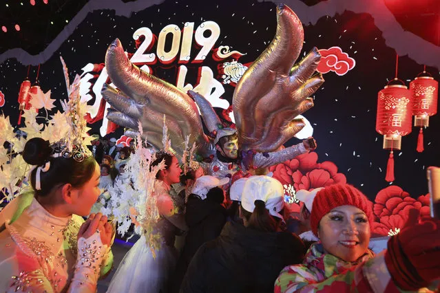 Performers take selfies at the end of a countdown to the new year event in Beijing, China, Tuesday, January 1, 2019. (Photo by Ng Han Guan/AP Photo)