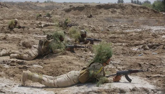 Iraqi security forces use bushes as camouflage as part of military training in Jurf al-Sakhar, Iraq April 9, 2015. (Photo by Alaa Al-Marjani/Reuters)