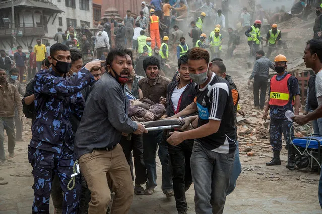 Emergency rescue workers carry a victim on a stretcher after Dharara tower collapsed on April 25, 2015 in Kathmandu, Nepal. (Photo by Omar Havana/Getty Images)