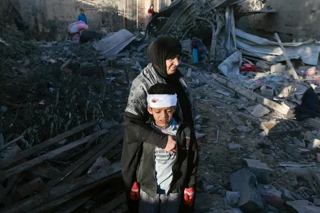 A Palestinian woman embraces a lightly injured boy as they check the rubble of a building following Israeli bombardment, on January 18, 2024 in Rafah in the southern Gaza Strip, amid ongoing battles between Israel and the Palestinian militant group Hamas. (Photo by AFP) Photo