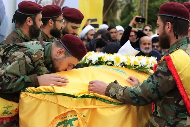 A Hezbollah fighter kisses the coffin of his comrade Ali Bazzi, who was killed with other two civilians by an Israeli airstrike that hit their house Tuesday night, during his funeral procession, in Bint Jbeil, South Lebanon, Wednesday, December 27, 2023. One Hezbollah fighter and two civilians, a newlywed couple, were killed in an overnight Israeli strike on a family-owned residential building in the town of Bint Jbeil, local residents and state media said Wednesday. (Photo by Mohammed Zaatari/AP Photo)