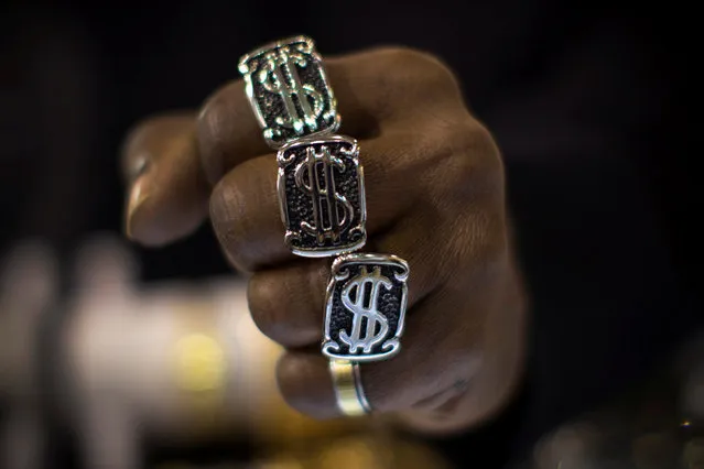 A man wears U.S. dollar sign rings in a jewellery shop in Manhattan in New York City November 6, 2014. (Photo by Mike Segar/Reuters)