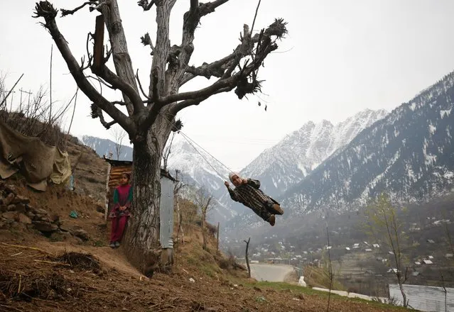 A Kashmiri girl plays on a swing made from rope atop a hill in a central Kashmir village of Kangan, March 23, 2016. (Photo by Farooq Khan/EPA)