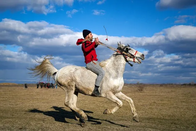 A man rides a horse during Epiphany celebrations in the village of Pietrosani, Romania, Friday, January 6, 2023. According to the local Epiphany traditions, following a religious service, villagers have their horses blessed with holy water and then compete in a race. (Photo by Vadim Ghirda/AP Photo)
