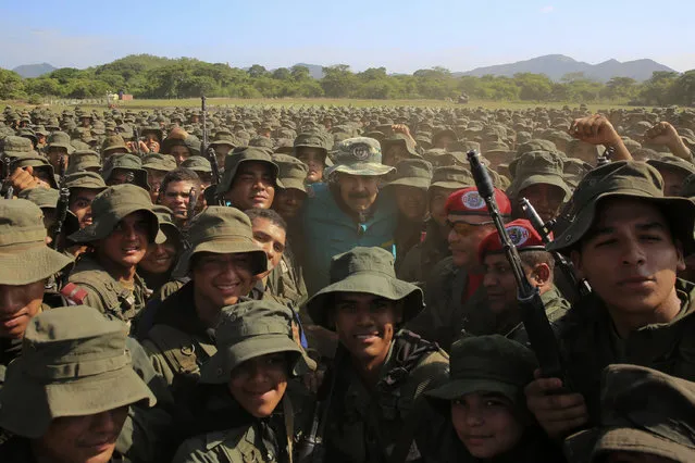 In this handout photo released by Miraflores Press Office, Venezuela's President Nicolas Maduro poses for a group photo with cadets at the G/J José Laurencio Silva training center in the state of Cojedes, Venezuela, Saturday, May 4, 2019. (Photo by Jhonn Zerpa/Miraflores Press Office via AP Photo)
